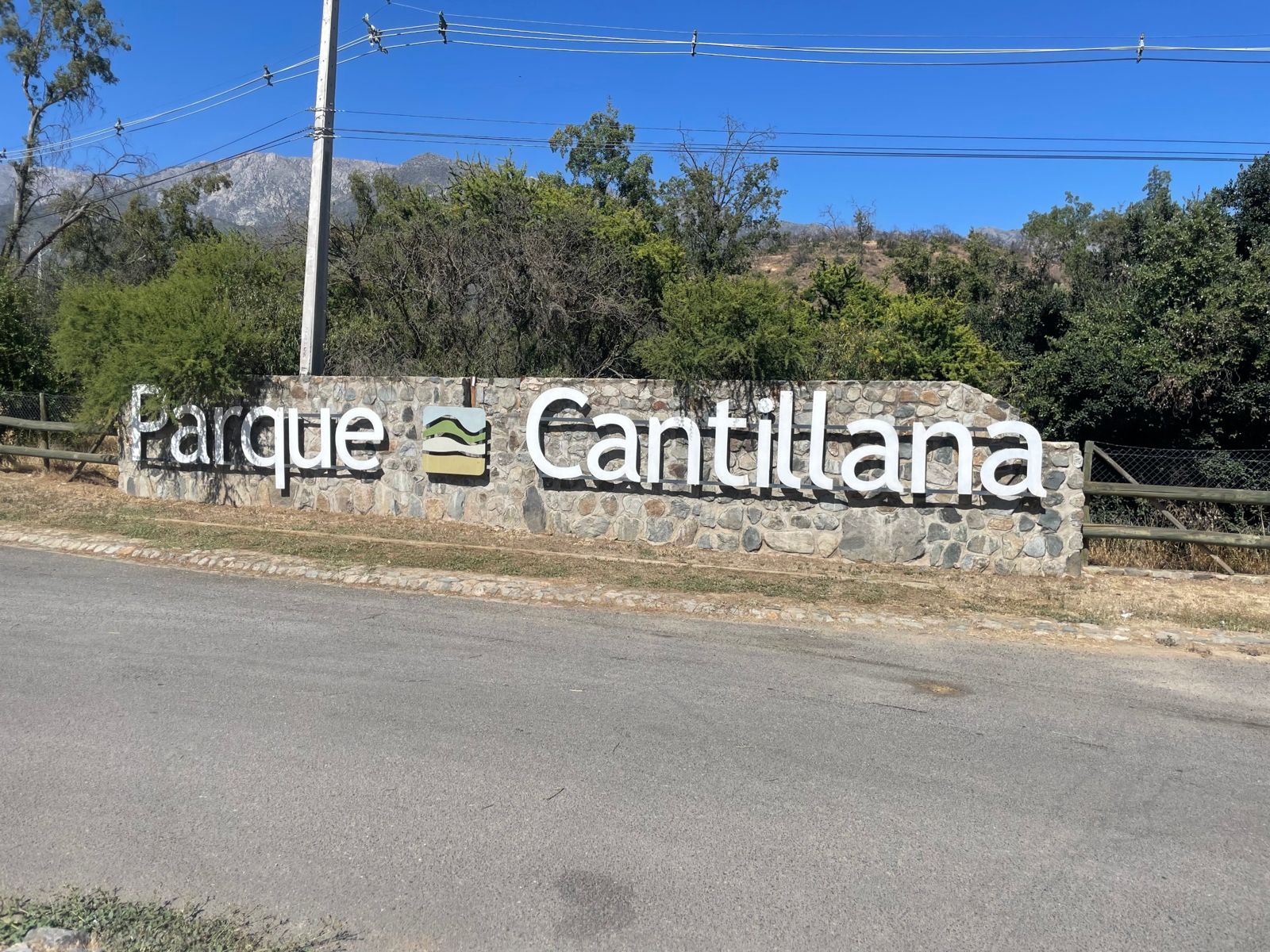 Letrero de Parque Cantillana con los cerros al fondo